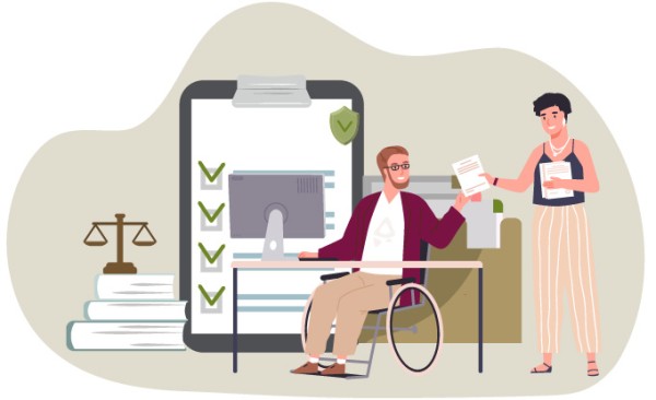 A man in a wheelchair works on the computer while a woman hands him documents.