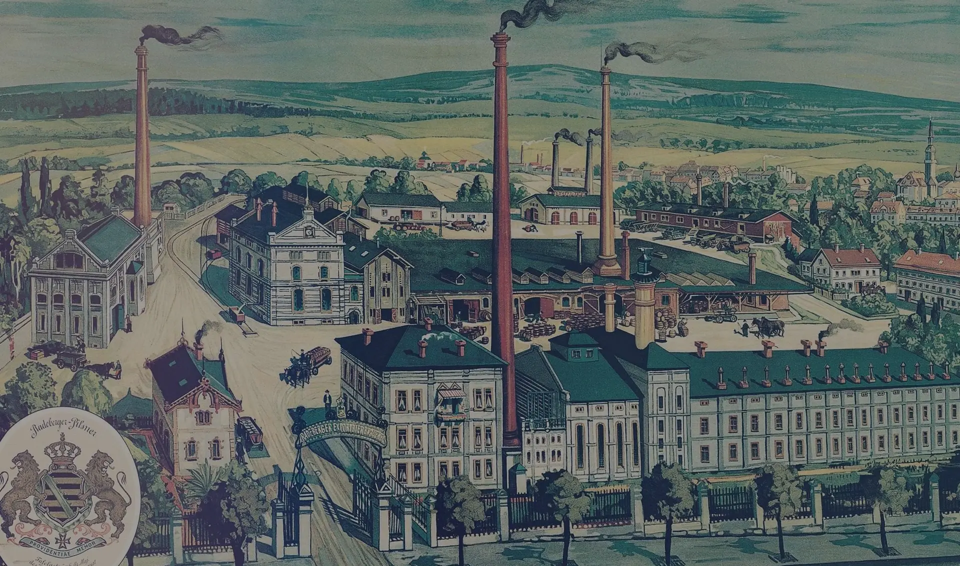 A vintage colored illustration depicts a bustling industrial complex with multiple buildings and smokestacks, set against a rural backdrop.